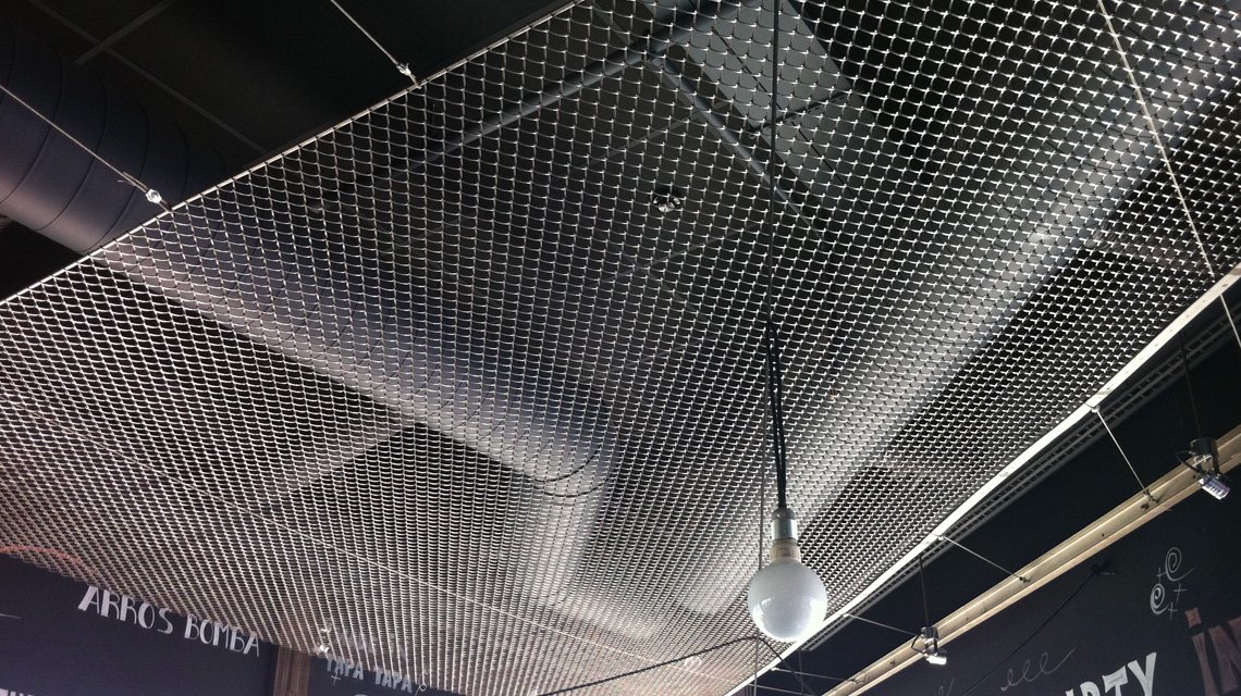résille métallique en acier inoxydable mise en pauvre en plafond d'un bar/restaurant @maillemetaldesign - <p>résille métallique inox GAUDI F tendue en plafond de ce bar/restaurant</p>